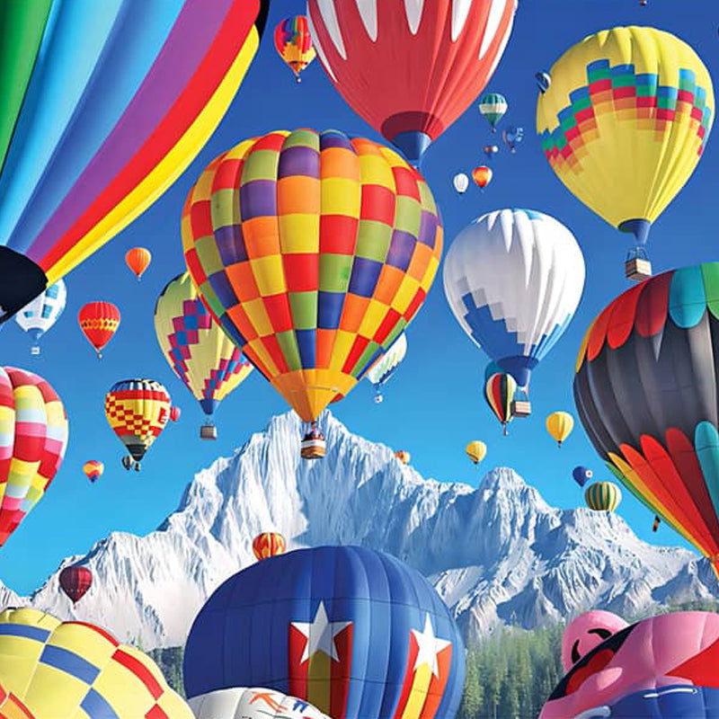 Colorful hot air balloons floating over snowy mountains with bright blue sky.