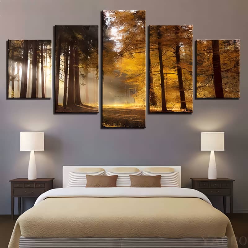 Diamond painting set of 5 pieces depicting a yellow autumn forest with sunbeams, displayed above a bed in a modern bedroom.
