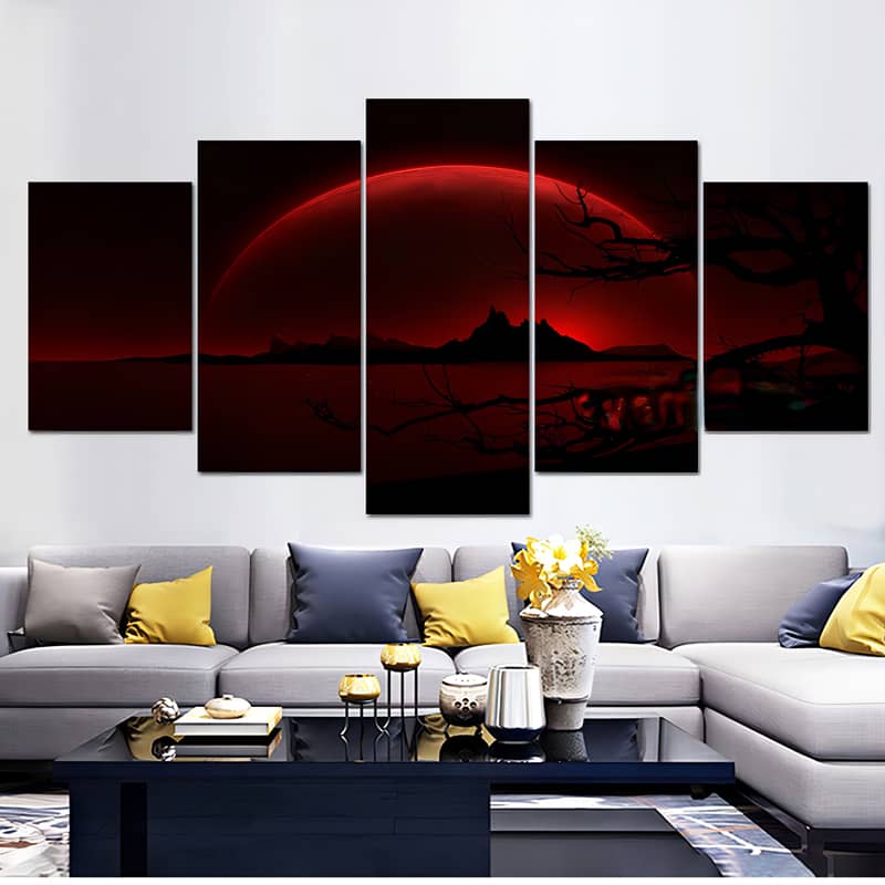 Five-piece diamond painting of a big red moon behind mountains, displayed above a modern living room sofa with decorative pillows and table.