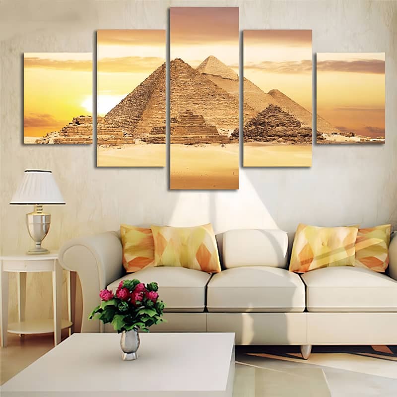 Diamond Painting 5-piece set depicting pyramids in the yellow sun, displayed above a modern white sofa with floral cushions.