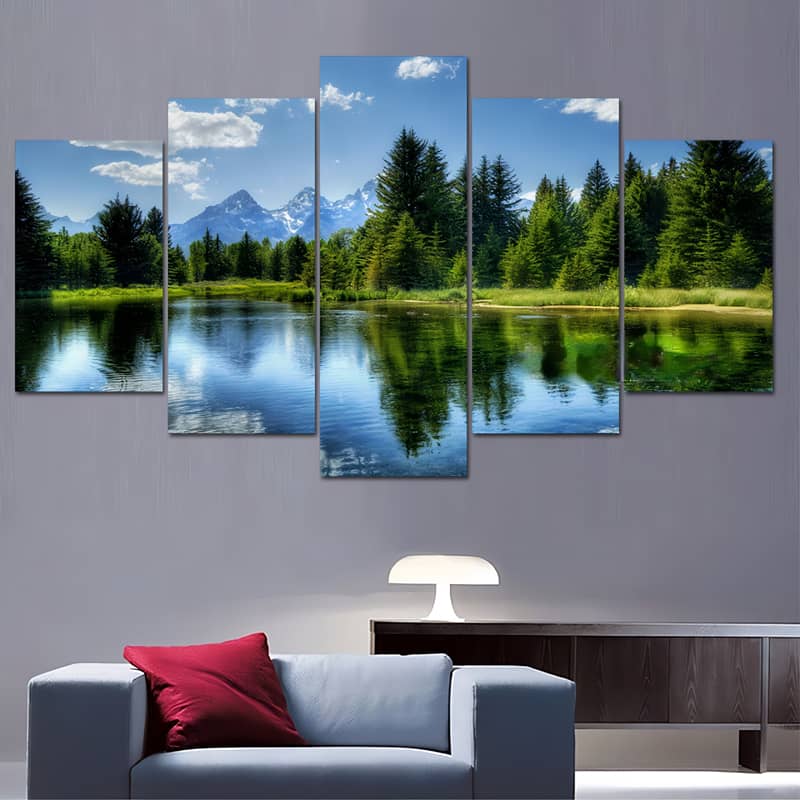Diamond painting 5-piece set of a serene forest lake with mountain backdrop and blue sky, displayed above modern living room sofa